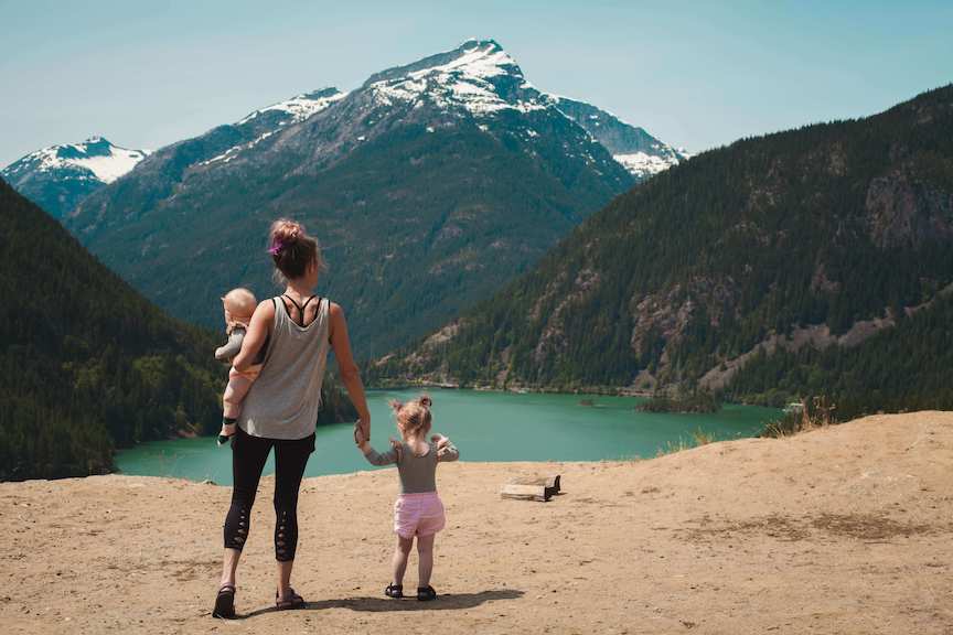 mom and kids looking out on mountains and lake