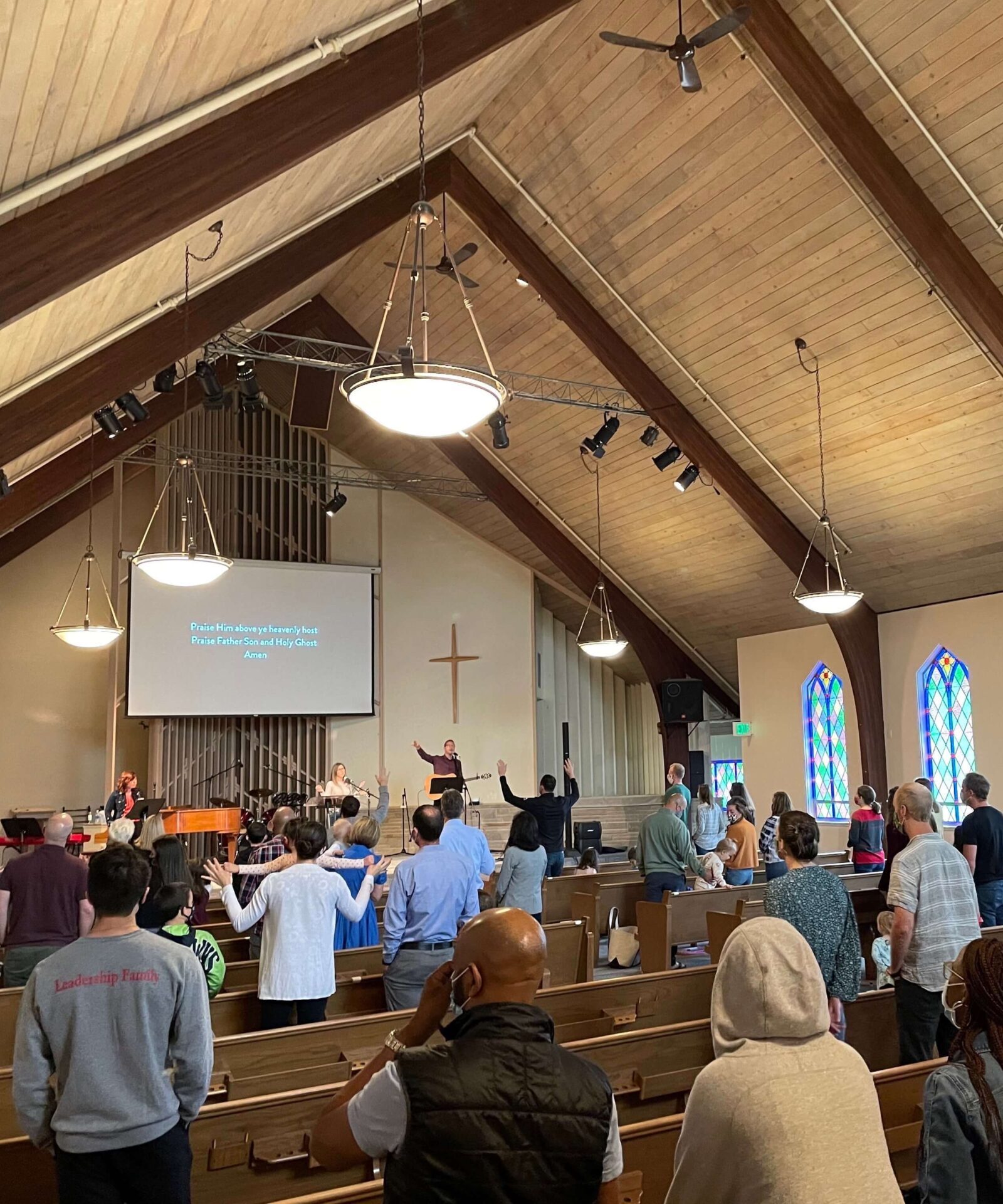 people raising hands in worship in a church sanctuary