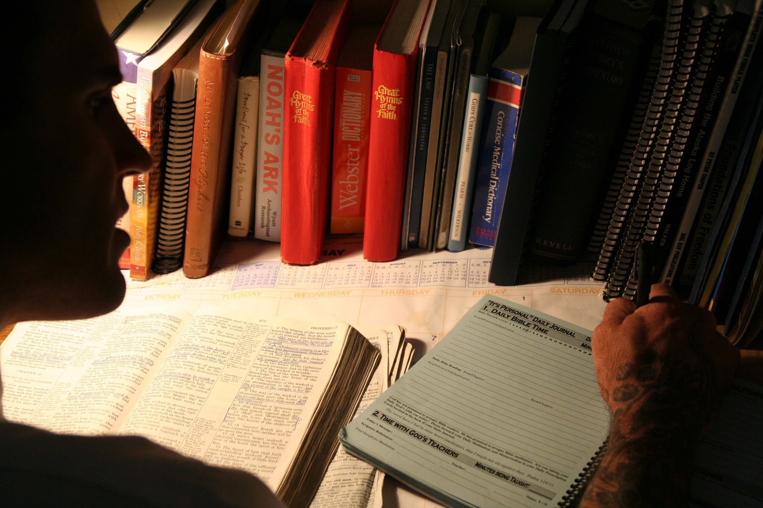 Picture of Bible, journal and a man studying the Bible.
